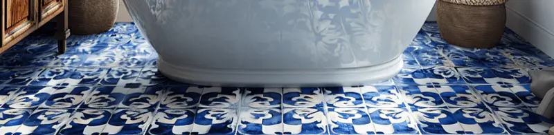 A bathroom floor adorned with blue and white mosaic tiles, arranged in a stunning Mediterranean-inspired pattern.
