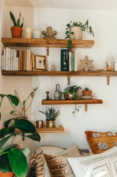 Boho bedroom, natural wood shelves, potted plants, small sculptures, candles, books..