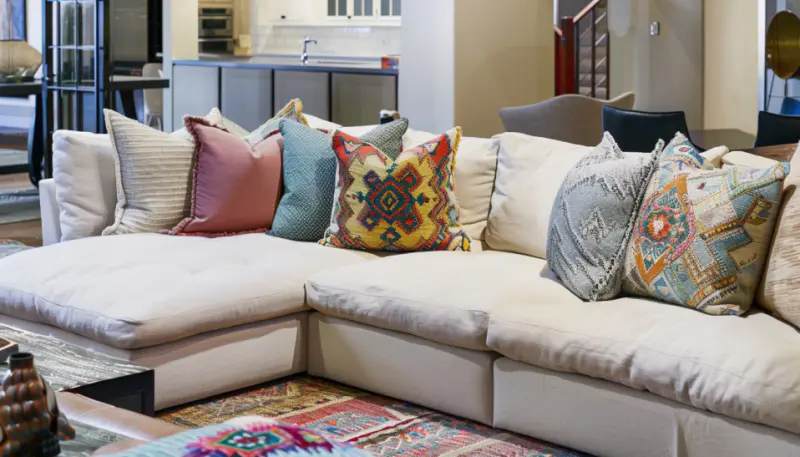 modern living room, neutral sofa, colorful pillows, patterned throws, stylish interior..