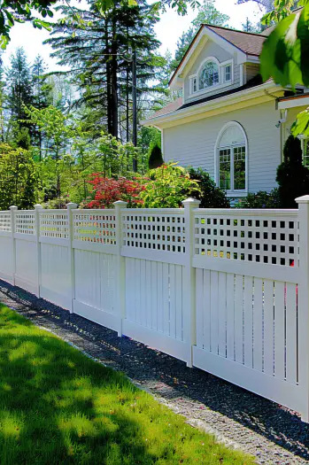 Wide shot of a backyard with a beige vinyl privacy fence