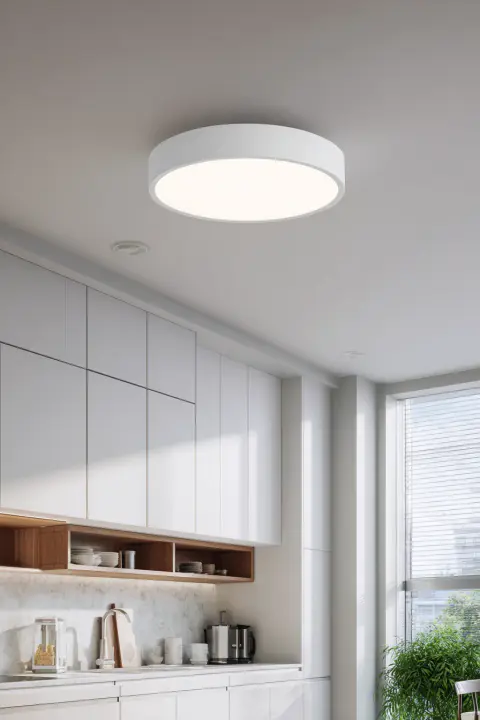 A modern flush mount kitchen ceiling light in a bright, minimalist kitchen with white cabinets, perfect for low ceilings. This kitchen ceiling light fixture provides ample light without sacrificing style.